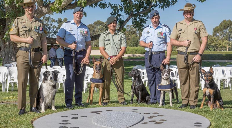 Australian Army Sergeant Stuart Conlin with Trip, RAAF Leading Aircraftman Gregory Chance with Veda, New Zealand Army Lance Corporal Maylin Broderick with Flicka, RAAF Leading Aircraftman Bradley Evans with Ollie and Australian Army Sapper Luke Saxton with Mate, at the new Military Working Dogs Memorial in Canberra. Photo by Leading Seaman Kylie Jagiello.