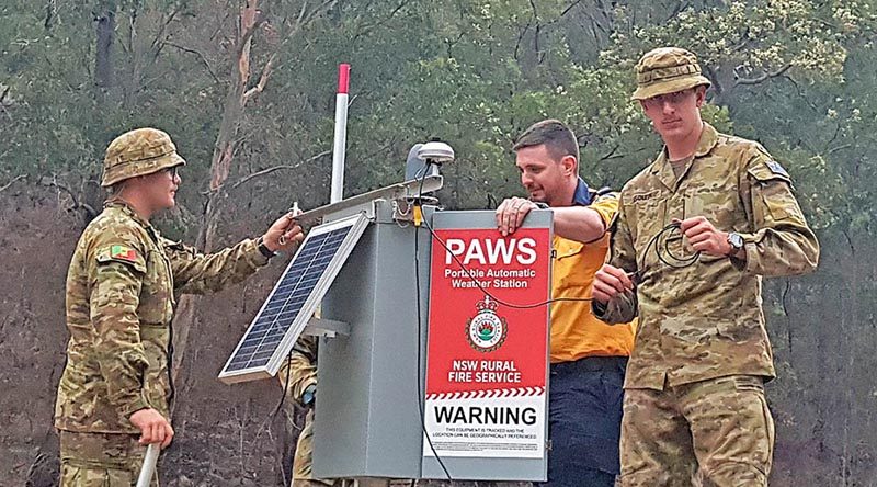 Privates Will Asquith and Aaron Smith help former Army major now NSW Rural Fire Service member Nick Sheply (centre) to set up a NSWRFS portable automatic weather station at Belowra on the New South Wales south coast.