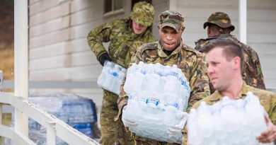 Papua New Guinea Defence Force sapper Moses Wai helps Australian Army soldiers move water at the Benambra Recreation Area. Photo by Corporal Sebastian Beurich.