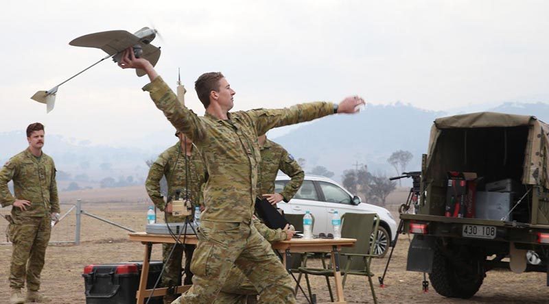 Bombardier Jarrod Logan launches a Wasp AE from a paddock 20km south of Canberra to survey blazing scrub in the Orroral Valley. Photo by Corporal Julia Whitwell.