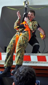 CDT Aaron Cahill experiences the AgustaWestland AW139’s winch simulator, operated by Aircrewman Guy Griffiths (Babcock Mission Critical Services Australasia, engaged in support of Air Ambulance Victoria). Photo by PLTOFF(AAFC) Jane McDonald.