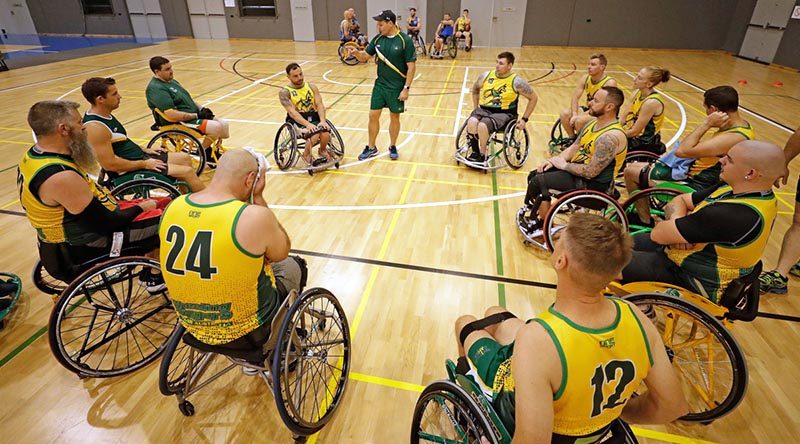 Australian Invictus Games Wheelchair sports coach Navy Warrant Officer Andrew Bertoncin speaks with the Wheelchair Basketball team during a training session in Townsville. Photo by Leading Seaman Jason Tufrey.