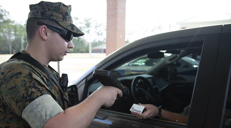 A US Marine Corps gate sentry demonstrates how sentries at entry control points will limit physical contact in the fight against COVID-19. US Marine Corps photo by Lance Corporal Taylor Smith.