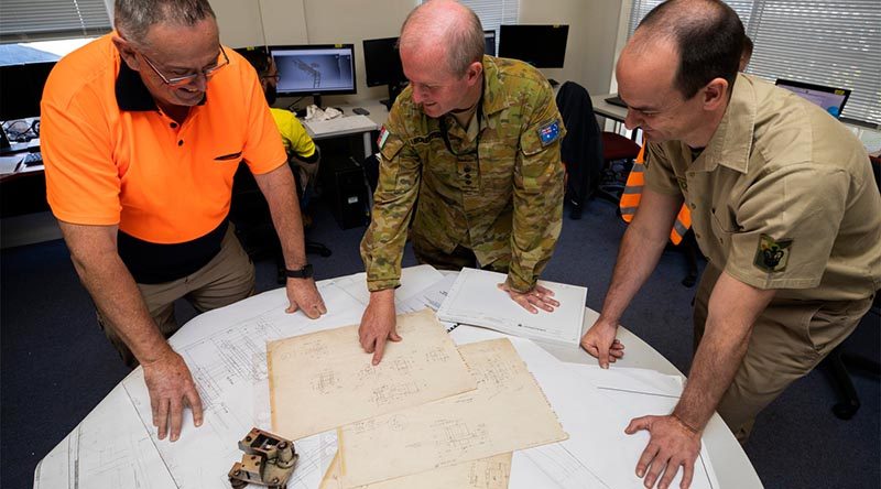 Colonel Bradley Robertson and Warrant Officer Class Two Steven Cosstick discuss options for making a replacement part for a surgical-mask manufacturing machine with David Mather at Med-Con Pty Ltd, a small manufacturer in Regional Victoria. Photo by Corporal Sagi Biderman.