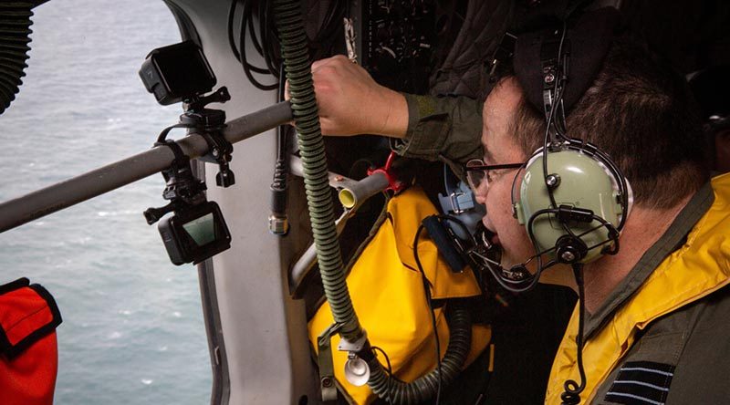 Deputy Director of Artificial Intelligence Wing Commander Michael Gan looks for a life raft off the Queensland coast during an assessment of the AI-Search system using GoPros for eyes. Photo by Corporal Jessica de Rouw.