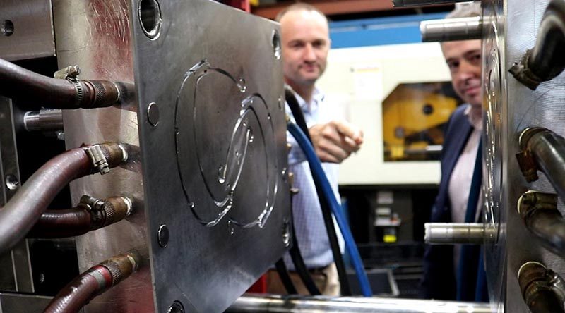 Axiom Managing Director Jim Grose and Ben Barona from Defence Science and Technology Group examine an injection moulding die used to manufacture face-mask components. ADF photo.