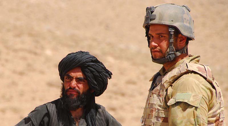 Private Jesse Bird interacts with a local at a vehicle check point while deployed with Mentoring and Reconstruction Task Force 2 (MRTF2). Photo by Corporal Rachel Ingram.