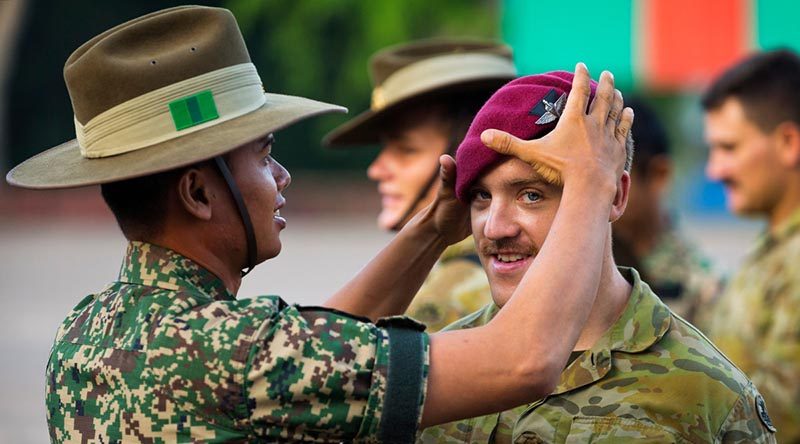 Australian Army soldier Private Jeremy Thomas of the 3rd Battalion, Royal Australian Regiment, swaps headdress with a Malaysian soldier following a Kapyong Day commemorative service in Malaysia during Indo-Pacific Endeavour 2019. Photo by Leading Seaman Jake Badior.