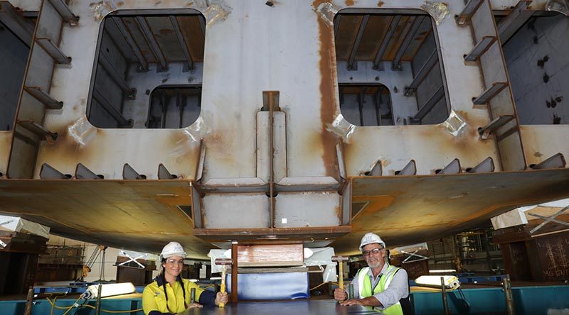 Evyenia Kontakos, a fourth-year apprentice welder and boilermaker with the Australian Submarine Corporation and Larry Lavallee, OPV Block Construction Manager, pose for an official photo after hammering in wedges to secure the Chief of Navy's ceremonial coin in place during NISHIP Eyre's keel laying ceremony. Photo by Russell Millard.