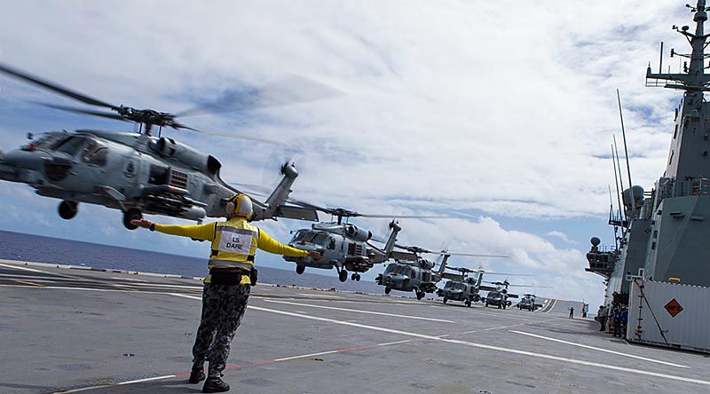 A single MH-60 Romeo helicopter (photo digitally altered) conducts a running take during first-of-class flight trials onboard HMAS Adelaide. Photo by Able Seaman Jarrod Mulvahill.