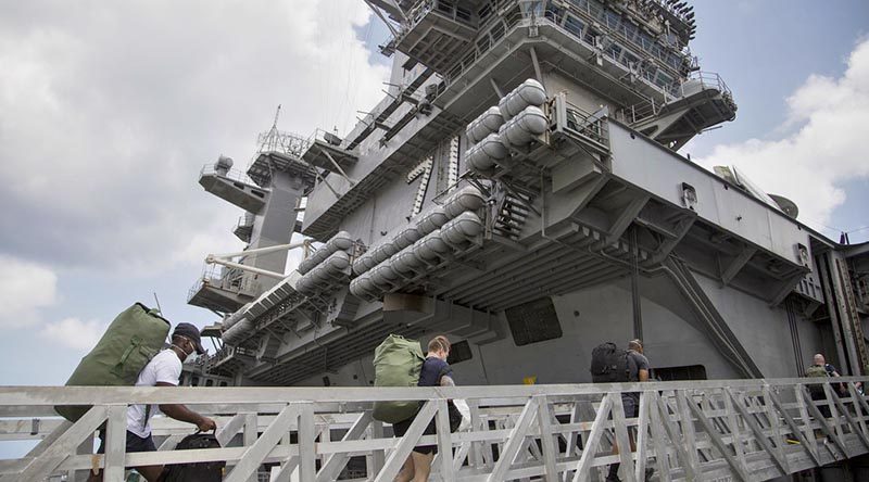 USS Theodore Roosevelt 'clean-crew' sailors re-board the aircraft carrier after completing their COVID-19 isolation period in Guam. Photo by US Marine Corps Staff Sergeant Jordan E Gilbert.