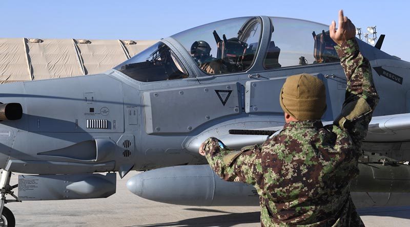 An Afghan Air Force A-29 Super Tucano crew chief give signals to his pilot before takeoff at Kandahar Airfield, Afghanistan. The AAF has an approved strength of about 8000 aircrew, maintainers and support staff. AAF is based at three air wings and multiple detachments across Afghanistan. US Air Force photo by Staff Sergeant Sean Martin.