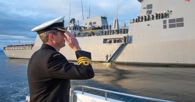 Commanding Officer HMAS Sydney (V) Commander Edward Seymour salutes his crew inside Jervis Bay, NSW, following the ship's commissioning ceremony at sea. Photo by Petty Officer Tom Gibson.