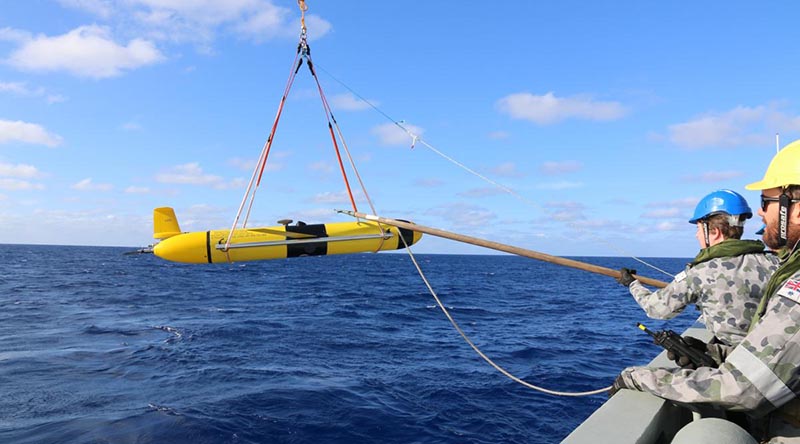 HMAS Melville crewmembers deploy a Slocum Glider.