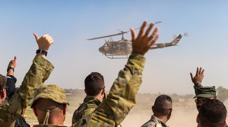 Australian soldiers and Iraqi forward air controllers wave to the crew of an Iraqi Army helicopter as it departs at the conclusion of training at Taji Military Complex, Iraq. Photo by Corporal David Said.
