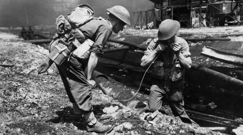 Sappers of the 2/4th Field Company prepare to blow up pipe lines obstructing the movement of tanks supporting the advance through the oil refinery area at Balikpapan. AWM 128776