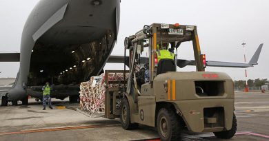 Aircraftman Joseph Freeman directs forklift driver Leading Aircraftman Christopher Wettenhall from No. 23 Squadron, during the physical loading of virtual conferencing systems onto a No. 36 Squadron C-17A Globemaster III bound for Fiji. Photo by Corporal Colin Dadd.