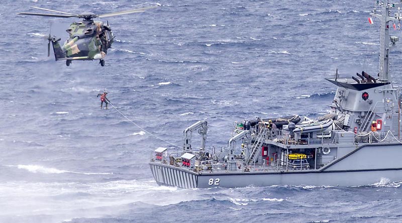 HMAS Choules' embarked MRH-90 Taipan helicopter conducts passenger transfer serials with HMAS Huon during the ships' transit to Vanuatu. Photo by Leading Seaman James McDougall.