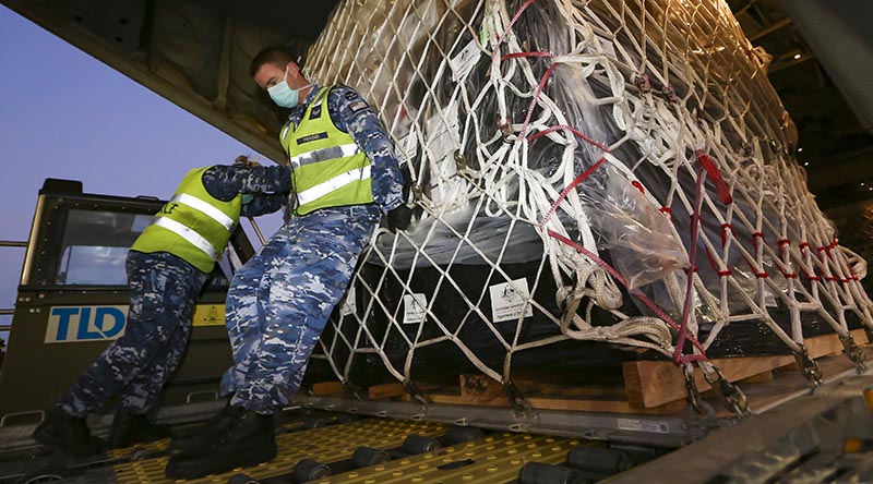 Royal Australian Air Force Air Movements Operator Corporal Adam Fraser from No. 23 Squadron, loads personal protective equipment destined for Indonesia on to a No. 37 Squadron C-130J Hercules at RAAF Base Amberley. Photo by Corporal Colin Dadd.