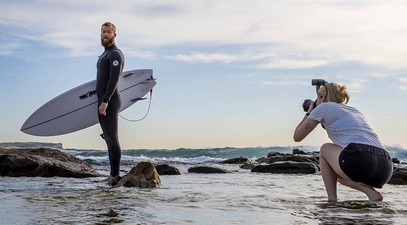 Royal Australian Air Force imagery-specialist trainee Aircraftwoman Emma Schwenke captures a portrait of Royal Australian Navy Leading Seaman Michael Douglas from HMAS Canberra, at Maroubra Beach. Photo by Sergeant Christopher Dickson.