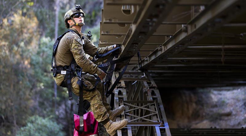 Lieutenant James Bonney attaches simulated explosives to a bridge during the final field phase of the Engineer Regimental Officer Basic Course. Photo by Sergeant Ray Vance.
