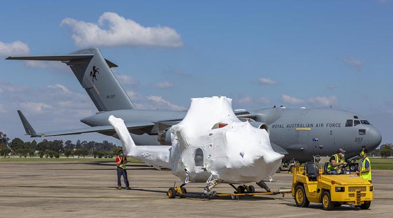 A new NSW Rural Fire Service Bell 412 helicopter is towed to a hangar after being unloaded from a RAAF C-17A at RAAF Base Richmond. Photo by Corporal Dan Pinhorn.