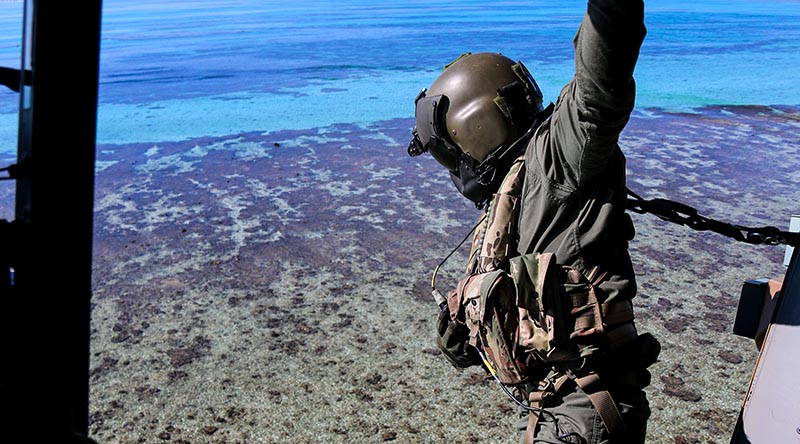 Petty Officer Rhys Withers in an MRH-90 helicopter looks over Elizabeth Reef during an unexploded ordnance clearance mission. Photo by Sergeant Jake Sims.