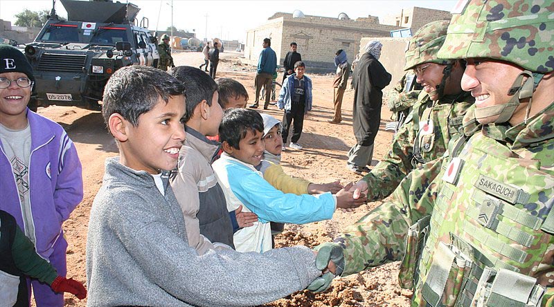 Iraqi children shake hands with JGSDF soldiers during a reconstruction operation. Photo by Rikujojieitai Boueisho, via WikiCommons.