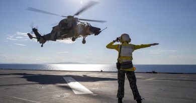 Able Seaman Lily Hardin waves off an Army ARH-Tiger as it takes off from the deck of HMAS Adelaide near Townsville during Exercise Sea Wader. Photo by Leading Seaman Nadav Harel.