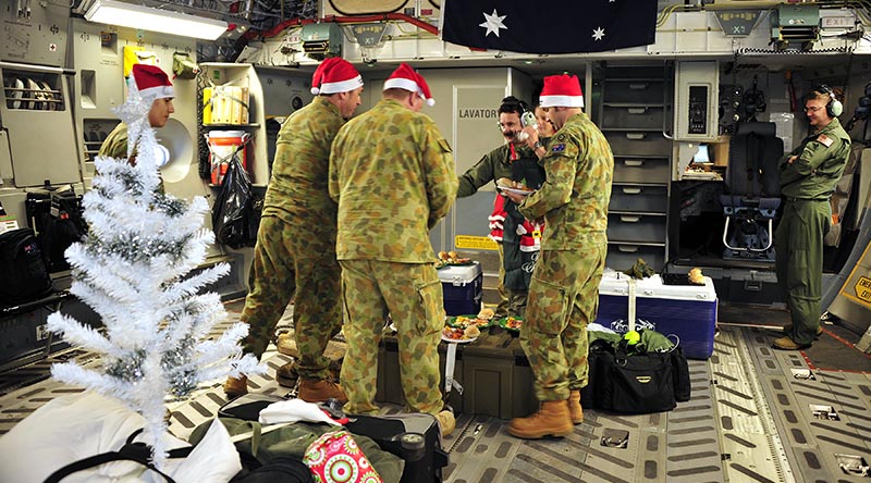 Aircrew from No. 36 Squadron, RAAF Base Amberley, enjoy a semi-traditional Christmas lunch onboard a C-17A Globemaster in transit to the Middle East. Photo by Sergeant W Guthrie.