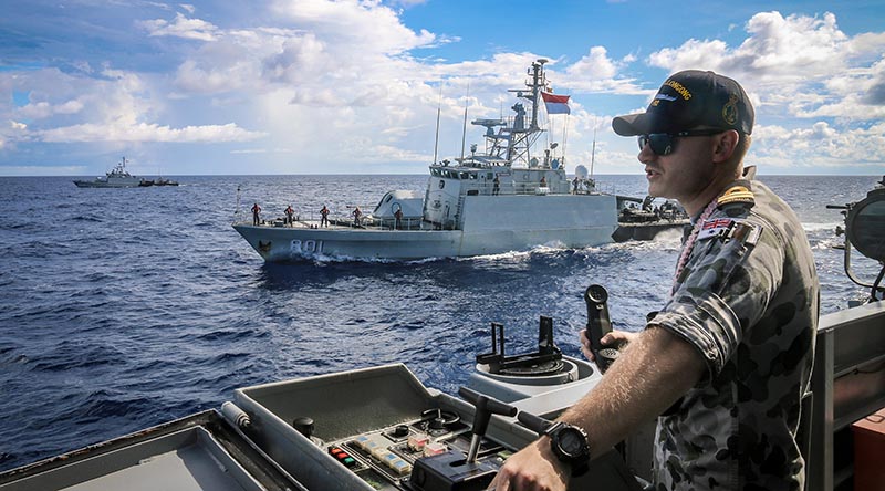 Lieutenant Bradley Chivers of HMAS Wollongong keeps watch during a coordinated maritime patrol in waters between Australia and Indonesia with KRI Pandrong and KRI Lemadang. Photographer unknown.