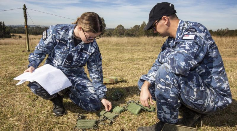 Leading Aircraftwoman Kate Kershaw and Leading Aircraftman Jordan Hopkins erect an aerial for the UXO TrackS system trial. Photo by Sergeant Shane Gidall.