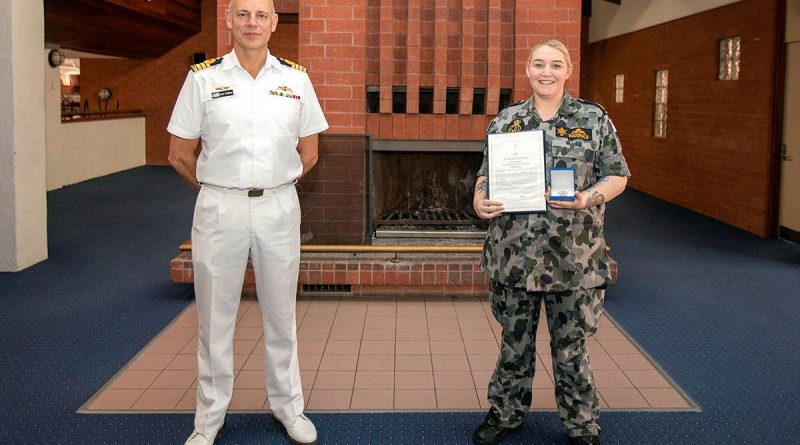 Captain Doug Theobald presents a Fleet Commander silver commendation to Able Seaman Sarah McDonald at an awards ceremony held at HMAS Stirling in Western Australia. Photo by Petty Officer Yuri Ramsey.