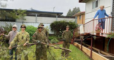 Connor Nish, left, and 41st Battalion, Royal New South Wales Regiment, soldiers Private Callum Nish, Private John Koronui, Corporal Paul Kohlhagen and Private Tom Mackney remove branches from Myrie McPherson’s backyard.