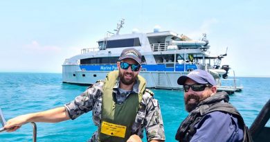 ADV Cape Inscription Navigation Officer Lieutenant Rhys Worboys and Great Barrier Reef Marine Park Authority officer Dwaine Butcher in front of Reef Ranger, a Queensland Parks and Wildlife Service vessel.