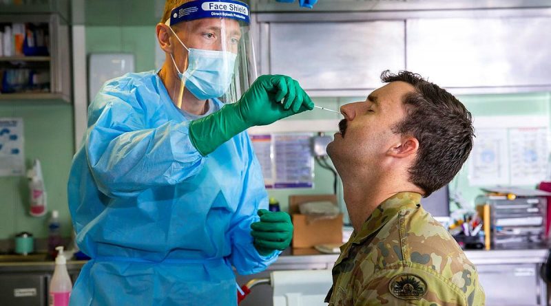 Lieutenant Nicholas Ilijas conducts a COVID-19 test in HMAS Adelaide as part of the COVID-19 safety protocols for Operation Fiji Assist. Photo by Corporal Dustin Anderson.