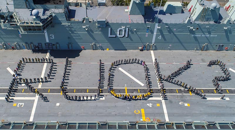 Officers and sailors on HMAS Adelaide's flight deck during a mental-health awareness event at Garden Island. Photo by Petty Officer Justin Brown.