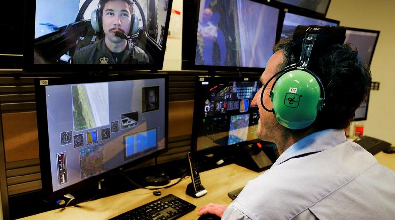 Simulator Pilot Instructor Ben Scorey, of Canadian Aviation Electronics, monitors and instructs Pilot Officer Alec Taylor in the Hawk 127 Simulator during a trial of eye tracking technology. Photo by Corporal Brett Sherriff.