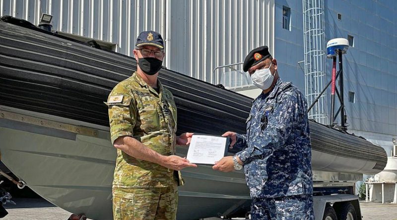 Commander of the Maritime Task Group – Middle East Region Captain Bruce Willington, left, presents the rigid hull inflatable boat to Bahrain Defence Force Captain Adel Salem Almeeri.
