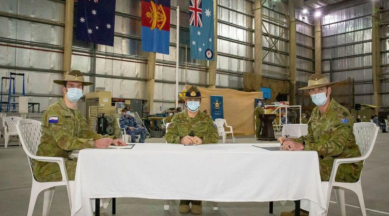 Major Justin Tomlinson, left, signs over authority to Major Simon Watch, right, with Commander JTF633 Rear Admiral Michael Rothwell. Photo by Sergeant Ben Dempster.