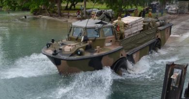 Papua New Guinean children watch a lighter amphibious resupply cargo - vehicle (LARC-V) retrieve ADF equipment from Manus Island, used to build temporary offshore immigration processing facilities. Royal Australian Navy photo.