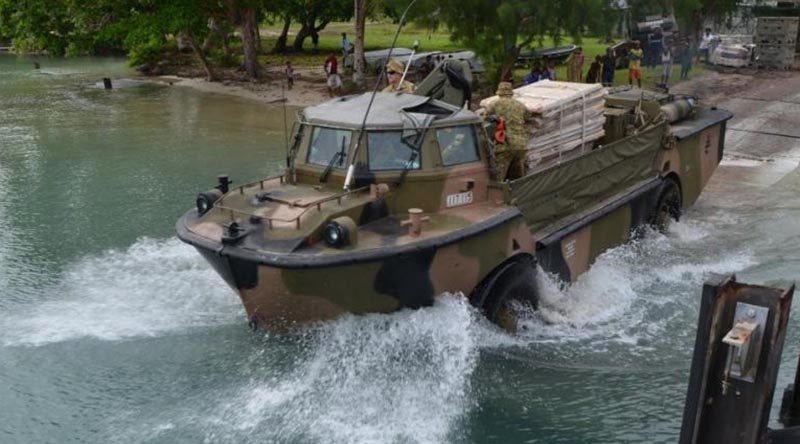 Papua New Guinean children watch a lighter amphibious resupply cargo - vehicle (LARC-V) retrieve ADF equipment from Manus Island, used to build temporary offshore immigration processing facilities. Royal Australian Navy photo.