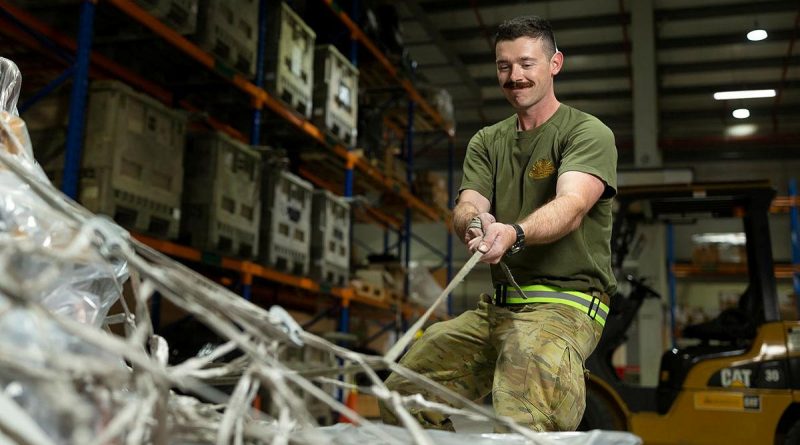 Private Mason Tessier secures cargo pallets in the warehouse of the ADF's main operating base in the Middle East, Camp Baird. Photo by Corporal Tristan Kennedy.