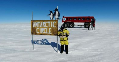 Sergeant Michelle Espley from No. 23 Squadron at the Antarctic Circle sign during Operation Southern Discovery.