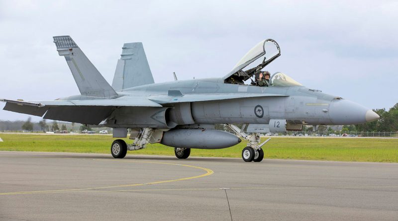 Caption: An Air Force F/A-18A Hornet aircraft from No. 77 Squadron taxis for the final time at RAAF Base Williamtown, New South Wales.