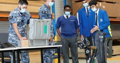 Leading Aircraftman Chris Carrigan, left, and Leading Aircraftman Jordan Hopkins demonstrate a vehicle used to detect Improvised Explosive Devices to Patrician Brothers students Amarjith Ajith, Agam Gujral and Damien Sinha, Photo by Corporal Kylie Gibson.