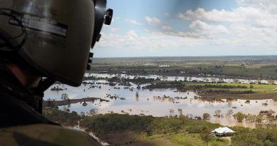 A helicopter loadmaster surveys floodwaters near Bundaberg, Queensland (2013). Photograph by Corporal Janine Fabre.