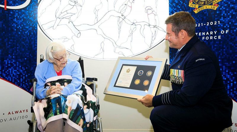 Senior Australian Defence Force Officer RAAF Base Amberley Group Captain Iain Carty presents Air Force veteran Mary Collins with an Air Force 2021 commemorative memento in celebration of her 100th birthday. Photo by Corporal Brett Sherriff.