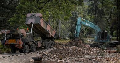 An Army HX77 and excavator being used to reconstruct a bridge near Wauchope, NSW, which was damaged by the floods. Photo by Private Jacob Hilton.