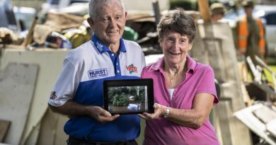 Alan and Janice Hunt stand in front of flood damaged possessions in Lower MacDonald, NSW. Photo by Corporal Sagi Biderman.